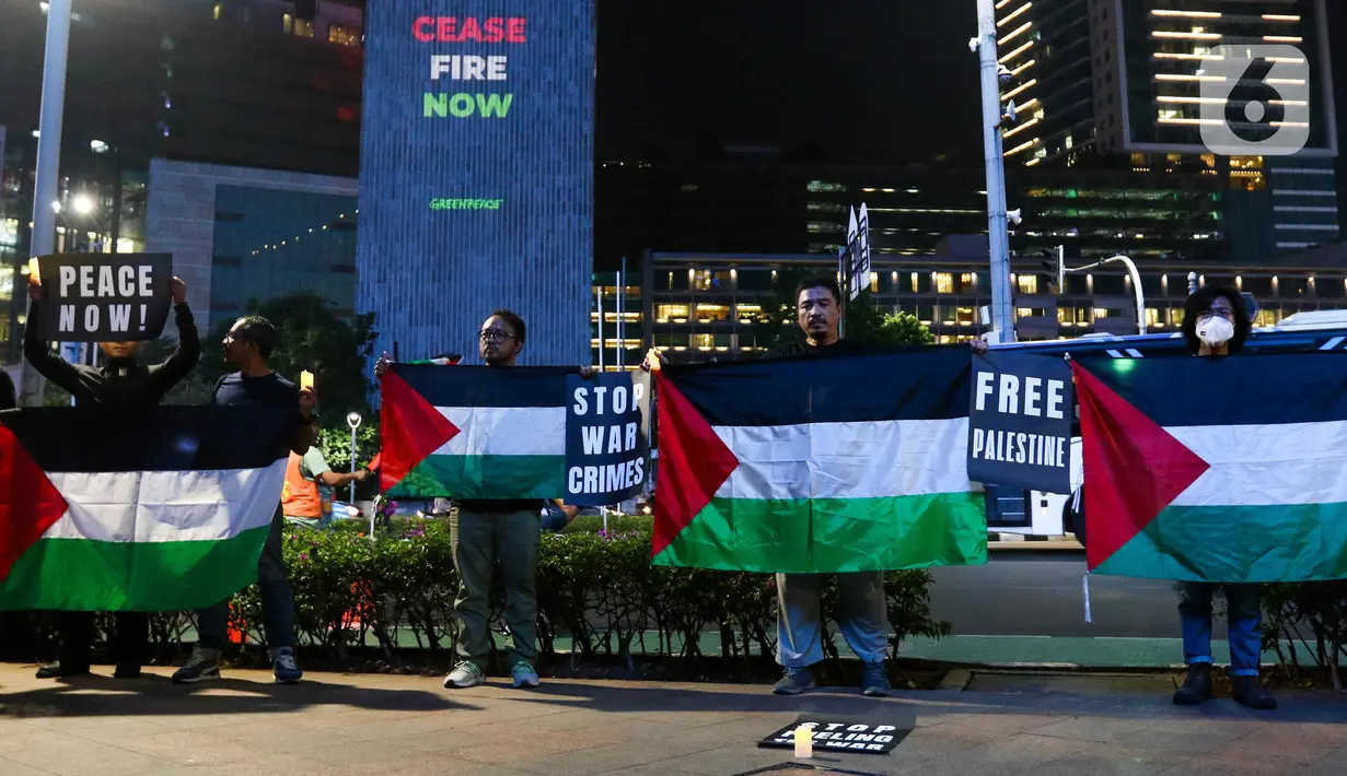 Dalam aksinya, aktivis Greenpeace Indonesia membawa poster dukungan dan mengibarkan bendera Palestina. (Liputan6.com/Herman Zakharia)