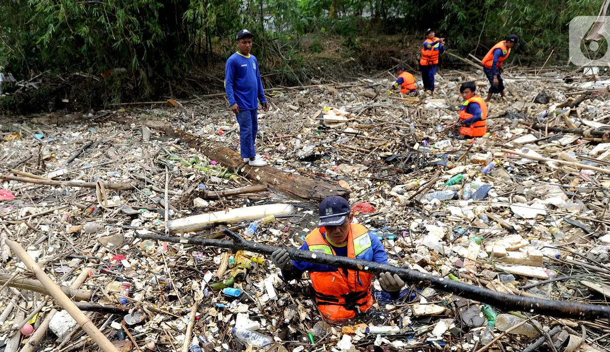 Petugas gabungan membersihkan tumpukan sampah yang menyumbat aliran air Sungai Cikeas di kawasan Bendung Koja Jatiasih, Bekasi, Jawa Barat, Rabu (16/10/2019). Pembersihan sekitar 1.200 meter kubik sampah bambu  tersebut diperkirakan menghabiskan waktu dua minggu. (merdeka.com/Arie Basuki)
