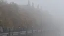Jalanan pinggir sungai Thames tertutup kabut tebal, London, Inggris, Senin (2/11/2015). Akibat kabut penerbangan di seluruh Inggris mengalamai penundaan dan pembatalan. (REUTERS/Stefan Wermuth)