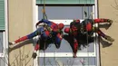Dua orang berpakaian superhero turun dari atap untuk memberi kejutan di jendela kamar pasien anak di bangsal Pediatri rumah sakit San Paolo di Milan, Italia, Rabu (15/12/2021). Saat beraksi, para superhero memanjat dengan menggunakan tali dibekali alat pengaman yang lengkap. (AP Photo/Luca Bruno)