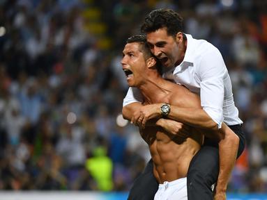 Cristiano Ronaldo menggendong salah satu staf Real Madrid saat merayakan kemenangan usai mengalahkan Atletico Madrid pada Final Liga Champions di San Siro Stadium, Milan, (29/5/2016) WIB. (AFP/Gerard Julien)