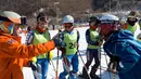 Pemain ski Korea Selatan dan Korea Utara bebincang saat mengikuti latihan di resor ski Masik Pass di Korea Utara, (1/2). Para pemain ski dan skater Korut tiba di bandara Korsel untuk berpartisipasi dalam Olimpiade Musim Dingin. (Korea Pool/Yonhap via AP)