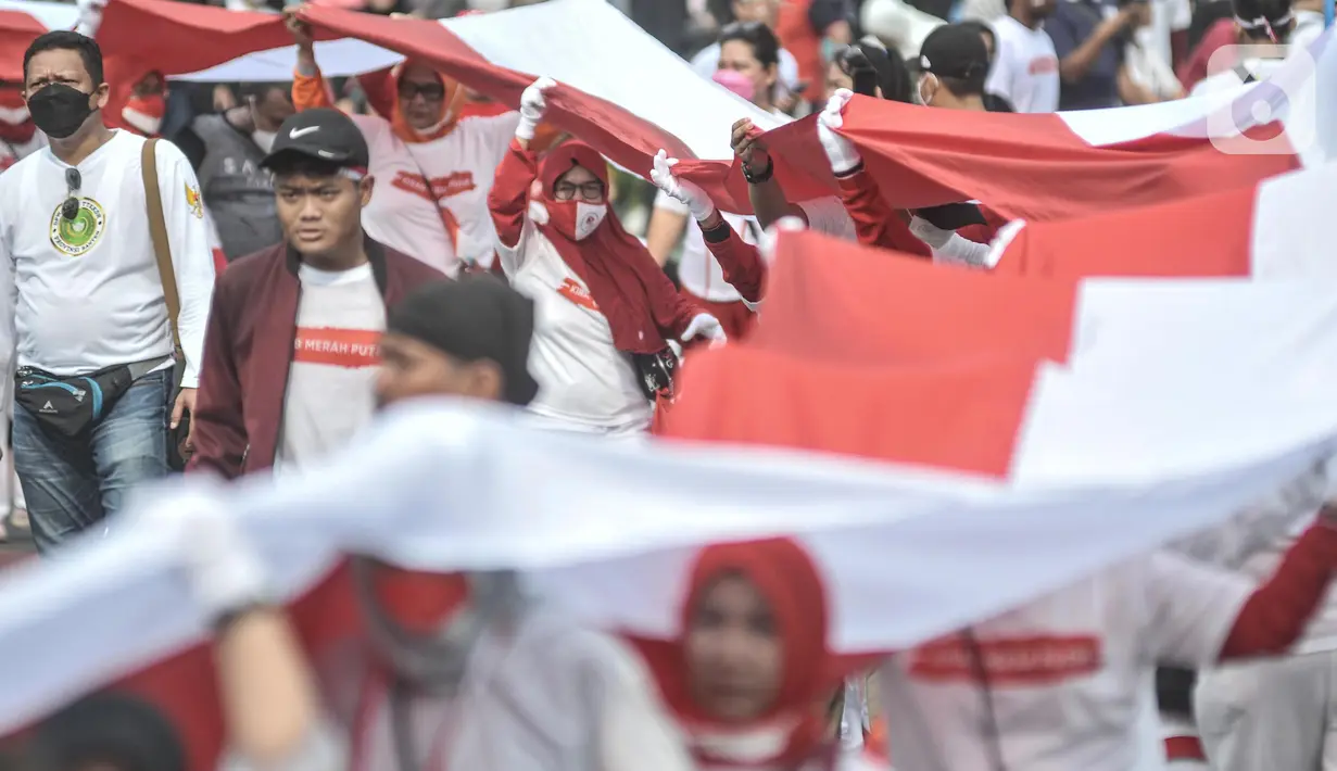 Peserta membentangkan bendera Merah Putih raksasa di kawasan Bundaran HI, Jakarta Pusat, Minggu (28/8/2022). Sebanyak 50.000 orang membentangkan bendera merah putih sepanjang 1.700 meter dari kawasan Monas hingga Bundaran HI yang merupakan rangkaian dalam memperingati Hari Kemerdekaan Indonesia dengan tema 'Pulih Lebih Cepat, Bangkit Lebih Kuat. (merdeka.com/Iqbal S Nugroho)