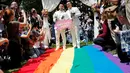 Pasangan sesama jenis berjalan di atas bendera pelangi raksasa saat melangsungkan pesta pernikahan mereka di Taipei, Taiwan, Jumat (24/5/2019). Taiwan menggelar pernikahan sesama jenis pertama di Asia. (REUTERS/Tyrone Siu)