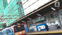 Kereta commuterline melintas dekat proyek pembangunan Apartemen Mahata Tanjung Barat di sekitar Stasiun Tanjung Barat, Jakarta, Kamis (30/1/2020). Proyek ini menempel Stasiun Tanjung Barat dan dekat dengan pusat perkantoran, pusat perbelanjaan, dan tempat rekreasi. (Liputan6.com/Immanuel Antonius)