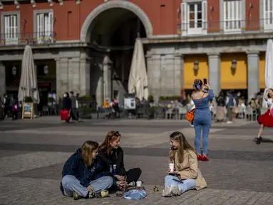 Sekelompok perempuan tanpa masker wajah berkumpul di alun-alun Plaza Mayor di pusat kota Madrid, Kamis (10//2/2022). Warga Spanyol untuk pertama kalinya dalam hampir dua bulan diperbolehkan tidak menggunakan masker di luar ruangan setelah peraturan terkait hal itu dicabut. (AP Photo/Manu Fernandez)