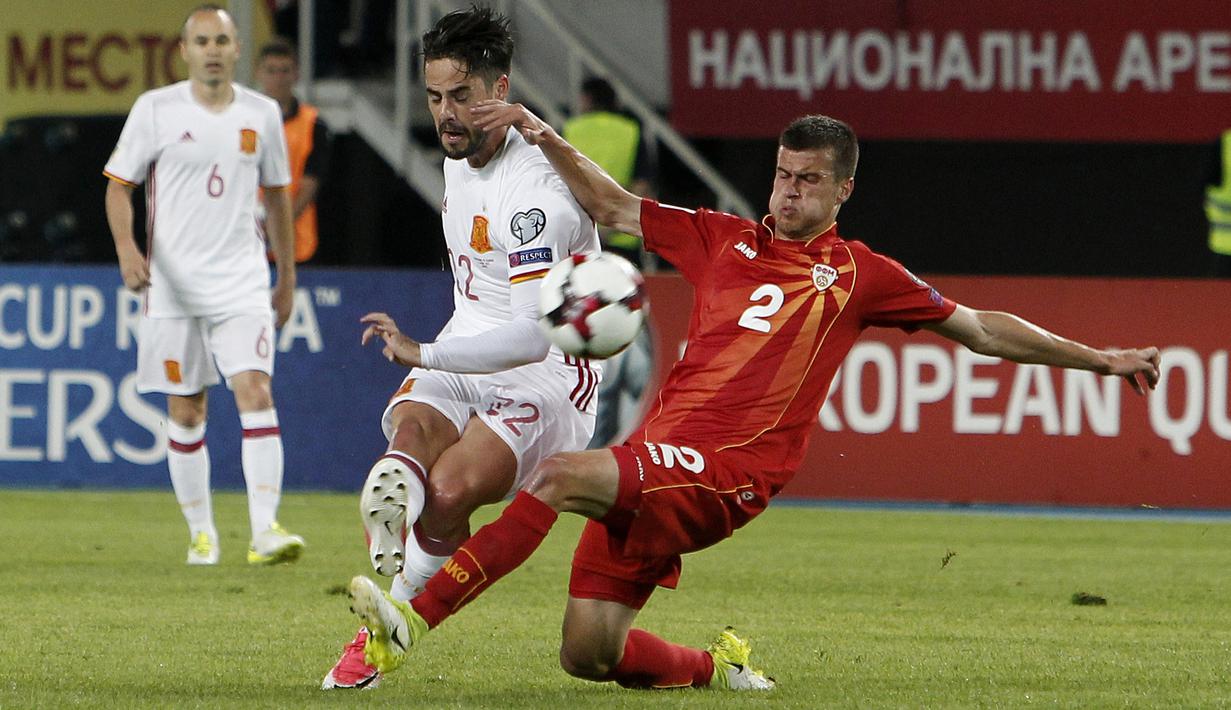 Isco (kiri) berebut bola dengan pemain Makedonia, Kristijan Tosevski pada laga kualifikasi Piala Dunia 2018 grup G di Philip II National Stadium, Skopje, MaKedonia, (11/6/2017). (AP/Boris Grdanoski)