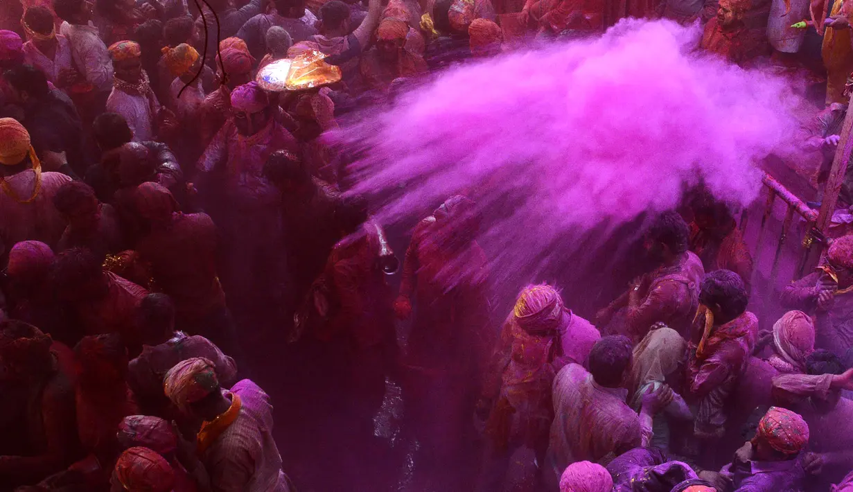 Peserta menaburkan bubuk berwarna selama perayaan Lathmar Holi di Barsana, Uttar Pradesh, India (6/3). Lathmar Holi adalah festival yang dirayakan sebelumnya Holi sebenarnya digelar. (AFP Photo/STR)