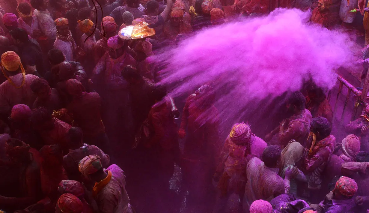 Peserta menaburkan bubuk berwarna selama perayaan Lathmar Holi di Barsana, Uttar Pradesh, India (6/3). Lathmar Holi adalah festival yang dirayakan sebelumnya Holi sebenarnya digelar. (AFP Photo/STR)