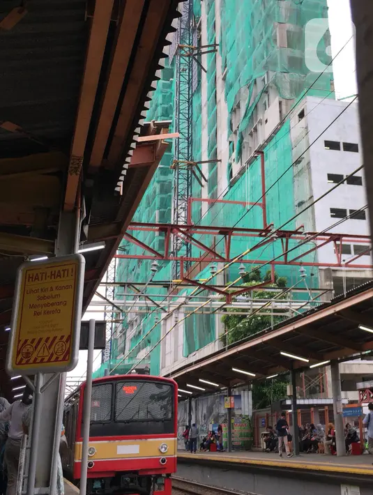 Kereta commuterline melintas dekat proyek pembangunan Apartemen Mahata Tanjung Barat di sekitar Stasiun Tanjung Barat, Jakarta, Kamis (30/1/2020). Apartemen Mahata Tanjung Barat dibangun di atas lahan seluas 15.244 meter persegi dan akan memiliki hunian sebanyak 1.216 unit. (Liputan6.com/Immanuel An