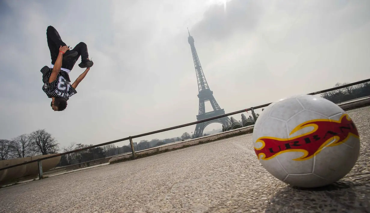 Aksi Moss bersalto dan mengolah bola di Place du Trocadero, dengan  latar menara Effeil, Paris, Jumat (18/3/2016).  S3 Society akan tampil pada Euro 2016 Pracis tanggal 10 Juni-10 Juli 2016. (AFP/Lionel Bonaventure)