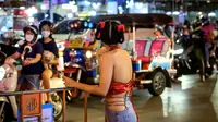 Seorang wanita berpose di jalan utama Chinatown Bangkok, didekorasi untuk menyambut Tahun Baru Imlek (9/2/2021). Perayaan Tahun Baru Imlek 2021 di Chinatown Yaowarat Bangkok secara resmi dibatalkan menurut Administrator Metropolitan Bangkok. (AFP/ Mladen Antonov)