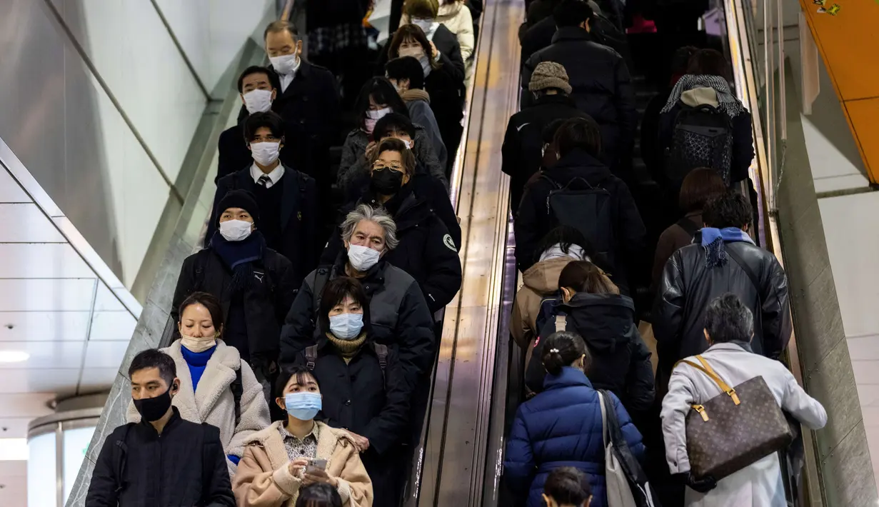Orang-orang yang memakai masker menggunakan eskalator di distrik Shibuya di Tokyo (19/1/2022). Pemerintah Jepang menyetujui pembatasan virus corona baru di sebagian besar negara, termasuk ibu kota untuk memerangi rekor infeksi yang dipicu oleh varian Omicron. (AFP/Behrouz Mehri)
