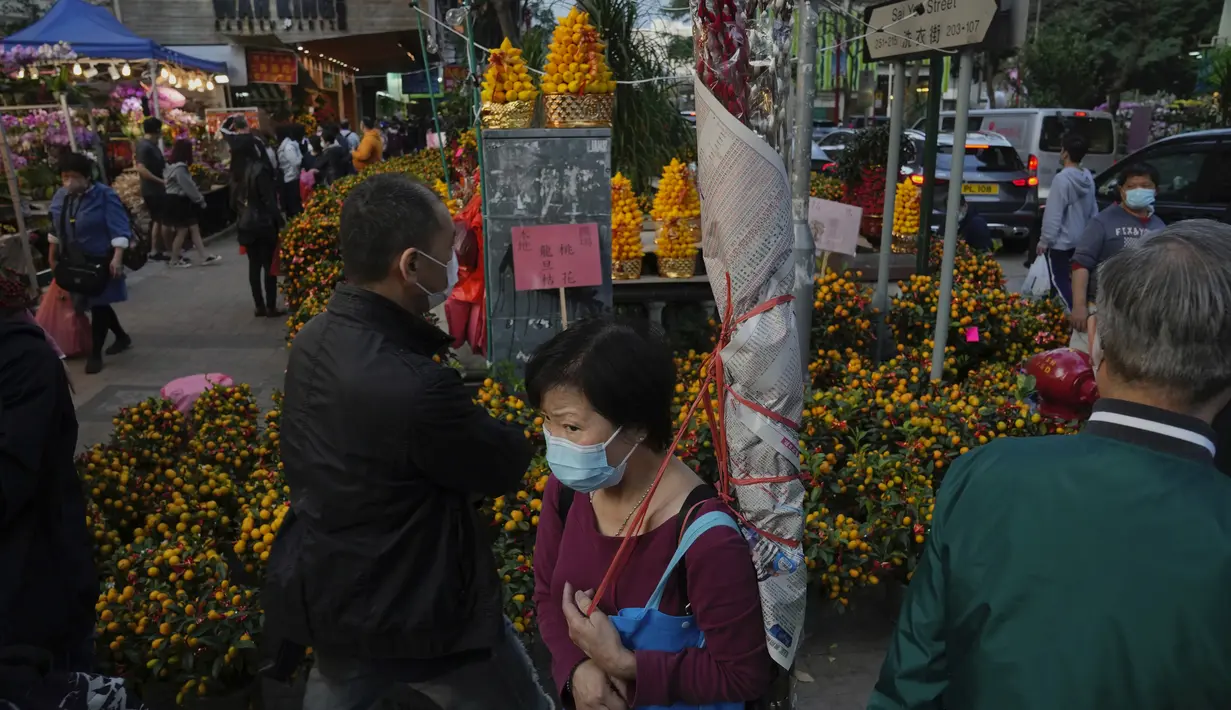 Orang-orang membeli bunga untuk merayakan Tahun Baru Imlek di Hong Kong, Rabu (19/1/2022). Tahun Baru Imlek China jatuh pada 1 Februari 2022. (AP Photo/Kin Cheung)