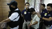 Petugas menggiring tersangka pelaku ledakan di Mall Alam Sutera berinisial LWK saat konferensi pers di Polda Metro Jaya, Jakarta, Kamis (29/10). LWK yang merupakan staf IT diduga melakukan pengebomannya atas dasar pemerasan. (Liputan6.com/Yoppy Renato)