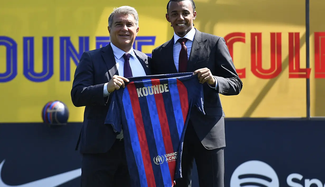 Bek baru Barcelona dari Prancis, Jules Kounde (kanan) berfoto sambil memegang jersey barunya bersama Presiden Barcelona Joan Laporta selama upacara presentasinya di tempat latihan Joan Gamper di Sant Joan Despi, Barcelona (1/8/2022). Kounde dikontrak untuk berseragam Blaugrana selama 5 tahun ke depan. (AFP/Pau Barrena)