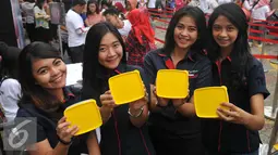 Sejumlah wanita menunjukan Tupperware gratis, Jakarta, Selasa (12/4).2500 Tupperware dibagikan secara gratis sebagai dukungan untuk membangun pola hidup sehat, hemat, dan ramah lingkungan melalui kebiasaan membawa bekal. (Liputan6.com/Gempur M Surya)