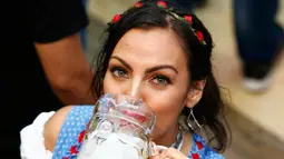 Seorang wanita menikmati bir saat menghadiri pembukaan Oktoberfest ke-183 di Munich, Jerman, Sabtu (17/9). (REUTERS/Michaela Rehle)
