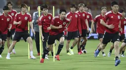 Para pemain Jepang melakukan pemanasan selama berlatih di Muscat, Oman, Senin (15/11/2021). Jepang duduk di posisi 3 dengan mengantongi 9 poin, selisih 2 angka dari Oman yang menguntit tepat di bawahnya. (AP Photo/Kamran Jebreili)