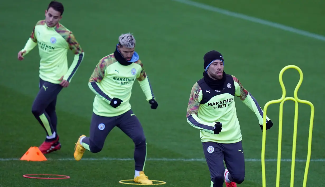Penyerang Manchester City, Sergio Aguero (tengah) dan bek Nicolas Otamendi (kanan)melakukan pemanasan selama sesi latihan di City Football Academy, Manchester, Inggris (25/2/2020). City akan bertanding melawan Real Madrid pada leg pertama babak 16 Liga Champions di Bernabeu. (AFP Photo/Jon Super)