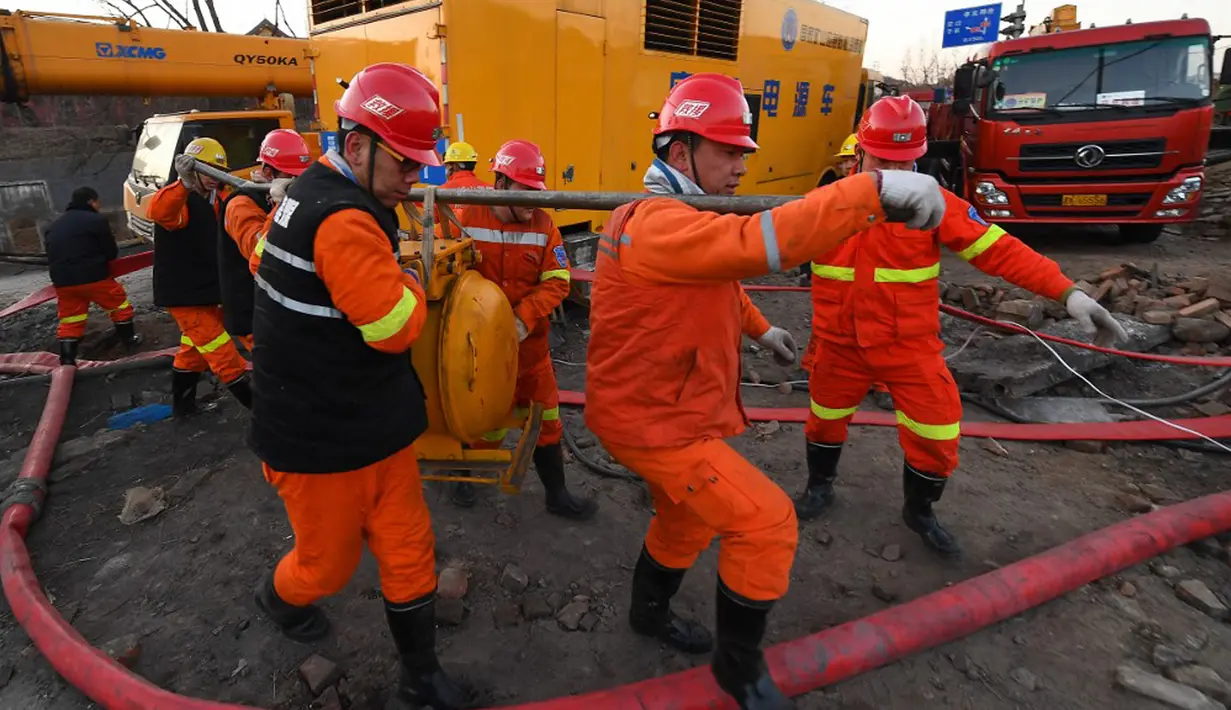 Tim penyelamat memindahkan pompa untuk mengalirkan air saat operasi penyelamatan penambang yang terperangkap dalam tambang batu bara di Xiaoyi, Shanxi, China, 16 Desember 2021. Upaya penyelamatan masih terus dilakukan. (STR/CNS/AFP)