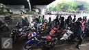 Pengendara sepeda motor berteduh di bawah flyover saat hujan turun, Jakarta, Senin (16/11). Petugas kepolisian akan menerapkan tilang dengan denda maksimal Rp250.000. (Liputan6.com/Immanuel Antonius)