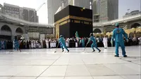 Para pekerja mensterilkan daerah di sekitar Kakbah di Masjid al-Haram, Makkah, Arab Saudi, Kamis (5/3/2020). Pemerintah Kerajaan Arab Saudi melalui  Wakil Menteri Kesehatan Abdel-Fattah Mashat melarang sementara penduduknya untuk melaksanakan ibadah umrah. (AP Photo/Amr Nabil)