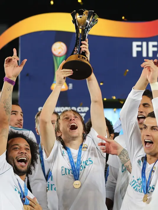 Gelandang Real Madrid, Luka Modric (tengah) mengangkat trofi Piala Dunia Antarklub 2017 di stadion Zayed Sports City di Abu Dhabi, Uni Emirat Arab, (16/12). Madrid sukses mengalahkan Gremio 1-0 berkat gol Cristiano Ronaldo. (AFP Photo / Karim Sahib)