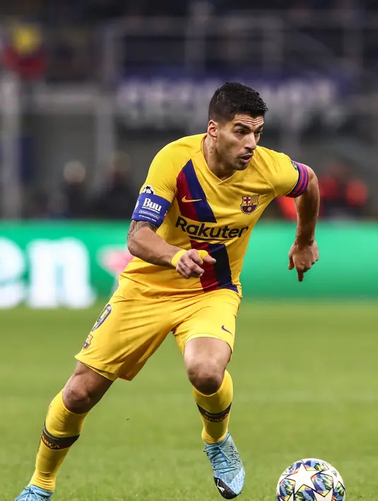 Penyerang Barcelona, Luis Suarez membawa bola saat bertanding melawan Inter Milan pada Grup F Liga Champions di stadion San Siro di Milan pada 10 Desember 2019. Suarez memilih hijrah ke Los Colchoneros setelah kontraknya di Barcelona diputus lebih awal. (AFP/Isabella Bonotto)