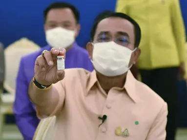 PM Thailand Prayuth Chan-ocha menunjukan vaksin Covid-19 AstraZeneca sebelum disuntik di Bangkok, Thailand (16/3/2021). Prayuth menjadi orang pertama di negara itu yang diinokulasi dengan vaksin AstraZeneca setelah peluncurannya ditunda. (Government Spokesman Office via AP)