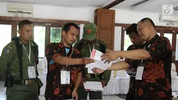 Dua petugas keamanan berjaga saat penghitungan suara Pilkada Jawa Barat 2018 di TPS 06 Nagrak, Gunung Putri, Bogor, Rabu (27/6). Di TPS ini pasangan Nomor Urut 4, Deddy Mizwar dan Dedi Mulyadi menang telak dengan 119 suara. (Liputan6.com/Herman Zakharia)