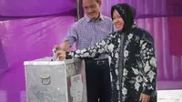 Walikota Surabaya Tri Rismaharini mencoblos bersama suaminya (Liputan6.com)