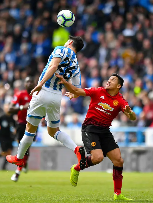 Pemain Huddersfield Town, Christopher Schindler berebut bola dengan penyerang sayap Manchester United, Alexis Sanchez pada pekan ke-37 Liga Inggris di John Smith's Stadium, Minggu (5/5/2019). MU gagal ke Liga Champions musim depan setelah ditahan Huddersfield Town 1-1. (Anthony Devlin/PA via AP)