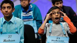 Sohum Sukhatankar (11), peserta dari Texas, bereaksi saat mendengarkan peserta lain mengeja dalam bahasa Inggris pada acara 90th Scripps National Spelling Bee di Oxon Hill, Maryland, Kamis (1/6). (AP Photo/Jacquelyn Martin)