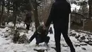 Seorang anak laki-laki bermain salju bersama keluarganya saat menghabiskan akhir pekan mereka di sebuah taman di Teheran utara, Iran, Jumat (25/12/2020). Musim dingin di Iran biasanya dimulai dari bulan Desember hingga Februari.  (AP Photo/Vahid Salemi)
