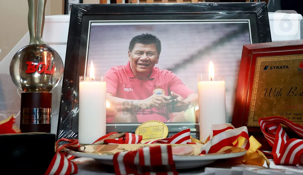 Foto mantan pelatih Tim Nasional Indonesia, Benny Dollo diletakkan dekat peti jenazahnya saat disemayamkan di rumah duka kawasan Pamulang, Tangerang Selatan, Kamis (2/2/2023). Jerry Simon, kerabat Benny Dolo yang ditemui di rumah duka mengatakan, mantan pelatih Persita Tangerang dan Arema FC itu sempat dirawat selama 4 hari di RS. (Bola.com/Muhammad Iqbal Ichsan)