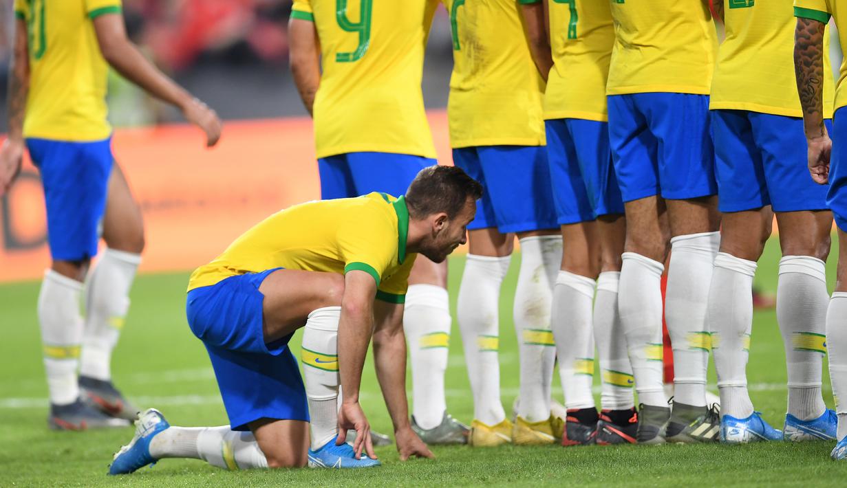 Gelandang Brasil, Arthur berlutut di belakang rekan-rekannya yang membuat pagar hidup untuk menjaga tendangan bebas pemain Korea Selatan dalam laga persahabatan di Mohammed Bin Zayed Stadium, Abu Dhabi, Selasa (19/11/2019). (AFP/Karim Sahib)