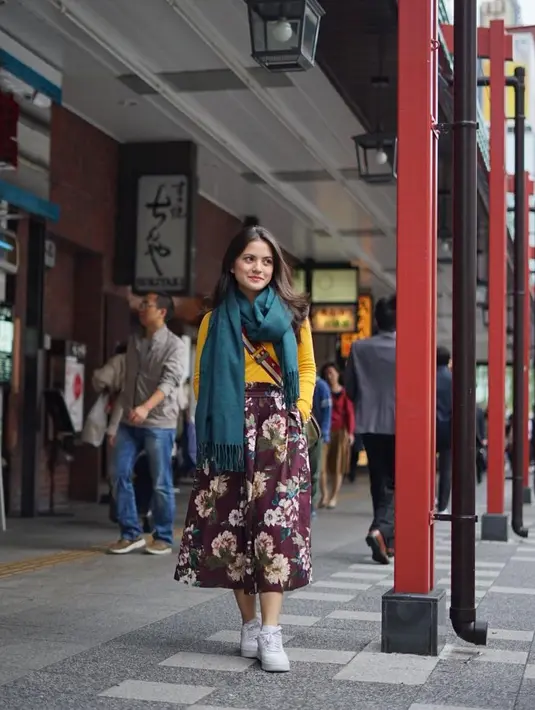 Celana kulot bermotif bunga-bunga, atasan berwarna kuning, scarf hijau tosca, dan sneakers putih. Mix and match warna yang tabrakan ini tak membuat Marsha menjadi tampil norak, justru ia lebih terlihat berwarna. (Instagram/aruanmarsha)