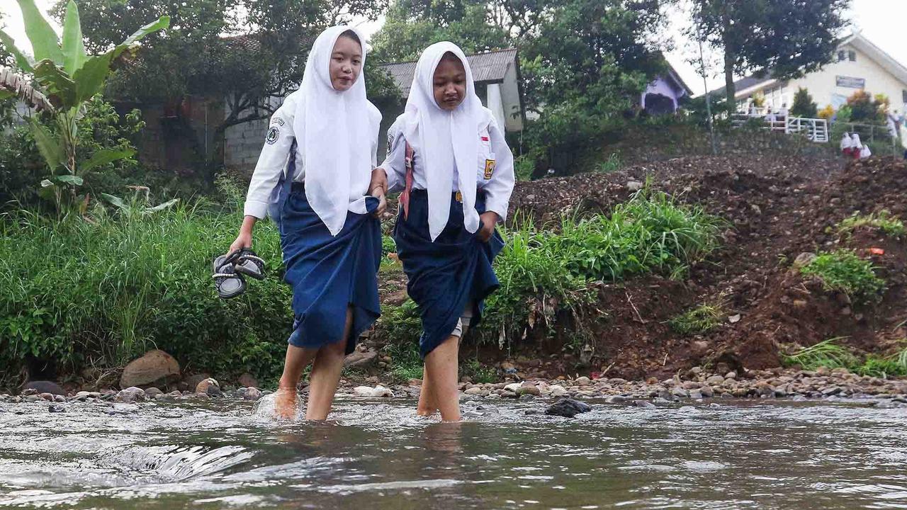 FOTO: Ketiadaan Jembatan  Penghubung Membuat Puluhan Siswa Menyeberang Sungai Menuju Sekolah di Dramaga Bogor