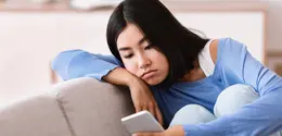 Ilustrasi perempuan dengan wajah kusam akibat paparan blue light dari smartphone ©Milkos