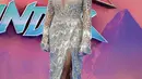 <p>Rita Ora berpose untuk fotografer setibanya di pemutaran film 'Thor: Love and Thunder di London (5/7/2022). Ia pun memakai sepasang sepatu hak perak metalik yang serasi dengan gaun yang dikenakan. (AP Photo/Scott Garfitt)</p>