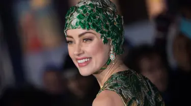 Aktris cantik Amber Heard berpose untuk fotografer setibanya menghadiri premier dunia film 'Aquaman' di London, Senin (26/11). Mantan istri aktor Johnny Depp ini datang dengan dibalut gaun couture dan hiasan kepala. (Vianney Le Caer/Invision/AP)