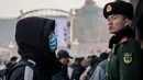 Seorang pria mengenakan masker penutup mulut setibanya di stasiun kereta api Beijing untuk mudik Tahun Baru Imlek pada Selasa (21/1/2020). Virus mirip SARS yang menyebar ke seluruh wilayah China dan mencapai tiga negara Asia ternyata dapat menular dari satu orang ke orang lain. (NICOLAS ASFOURI/AFP)