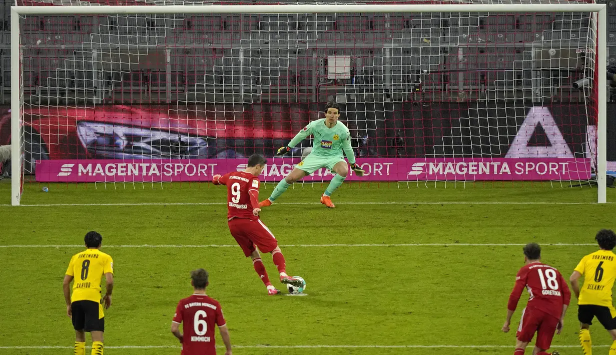 Penyerang Bayern Munchen, Robert Lewandowski mencetak gol kedua timnya dari titik penalti ke gawang Borrusia Dortmund pada pertandingan Bundesliga Jerman di Allianz Arena di Munich, Minggu (7/3/2021). Lewandowski mencetak tiga gol dan mengantar Munchen menang 4-2. (Guenter Schiffmann/Pool via AP)