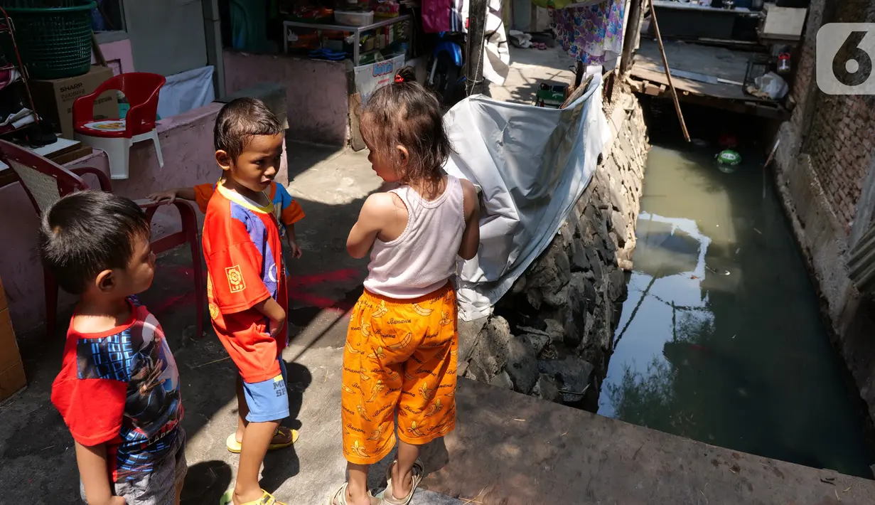 Anak-anak bermain di sekitar tempat tinggalnya di Gang Sekretaris, RT 015/RW 007 Tanjung Duren Utara, Jakarta Barat , Selasa (8/10/2019). Warga di kawasan tersebut tidak memiliki septic tank sehingga limbah hasil BAB langsung mengalir ke kali. (Liputan6.com/Herman Zakharia)