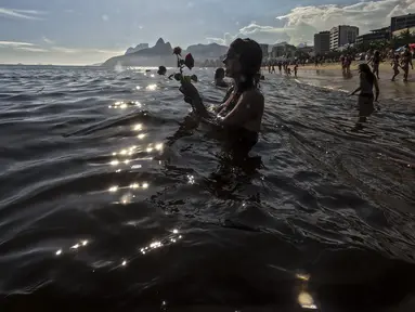 Pemuja dewi laut Yemanja menempatkan persembahan bunga di perairan pantai Arpoador selama perayaan tahunan di Rio de Janeiro, Brasil, Kamis, 2 Februari 2023. Dalam kepercayaan Afro-Brasil, Yemanja diyakini sebagai representasi dewi laut yang cantik jelita. (AP Photo/Bruna Prado)