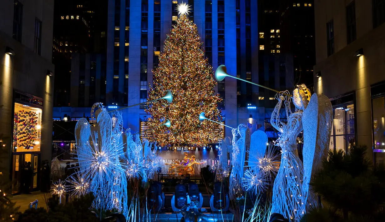 Lebih dari 50.000 lampu menghiasi Pohon Natal Rockefeller Center setinggi 75 kaki pada upacara tahunan pencahayaan di New York, Rabu (2/11/2020). Upacara yang digelar pada masa pandemi COVID-19 ini mewajibkan pengunjung untuk memakai masker, pembatasan waktu, dan jaga jarak. (AP Photo/Craig Ruttle)