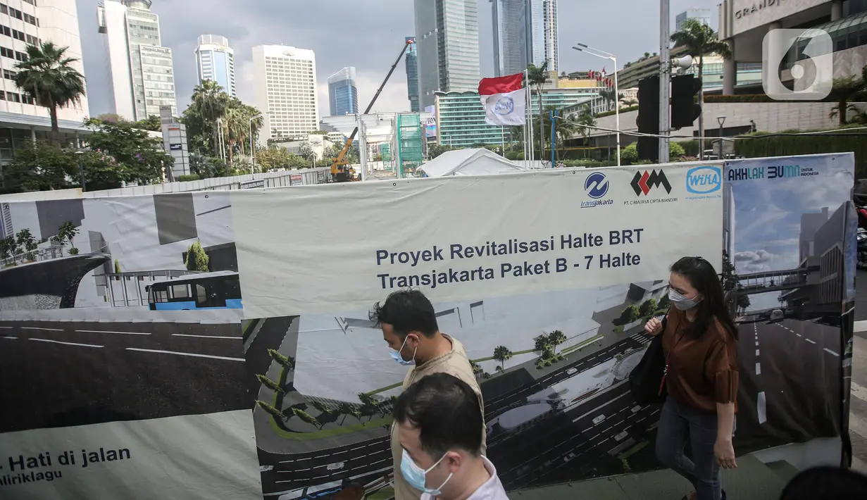 Penjalan kaki melintas di dekat proyek revitalisasi Halte TransJakarta Bundaran Hotel Indonesia di Jakarta, Kamis (15/4/2022). Sembilan halte TransJakarta akan difungsikan kembali secara bertahap sampai dengan diselesaikan secara keseluruhan pada Desember 2022. (Liputan6.com/Faizal Fanani)