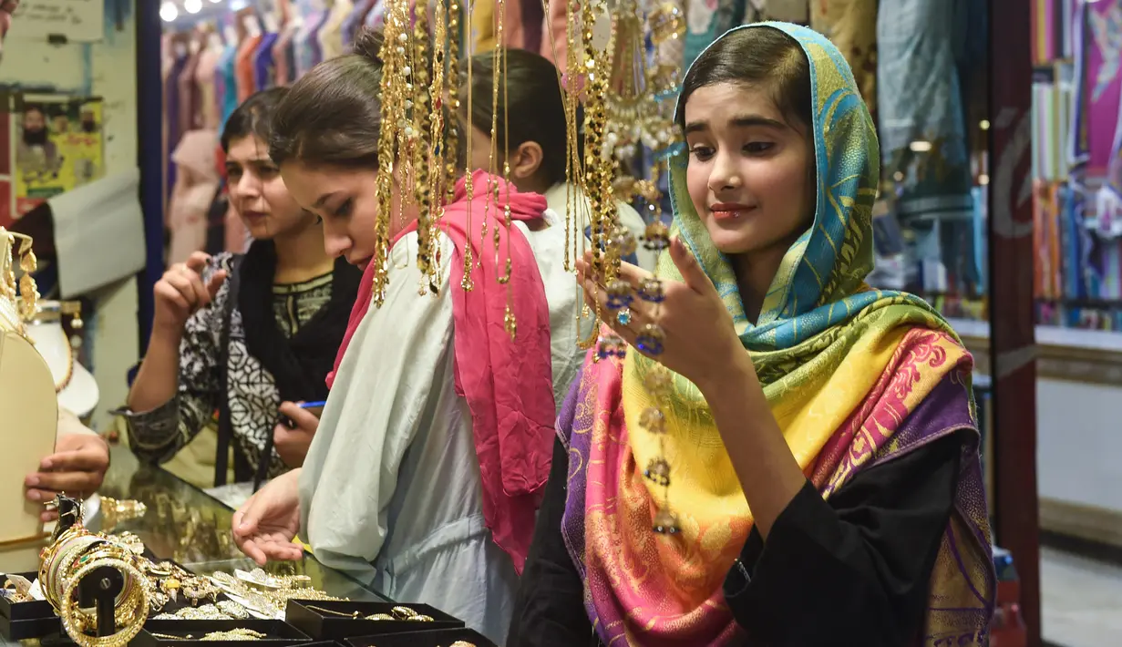 Seorang perempuan Pakistan memilih pernak-pernik di sebuah pasar di Lahore, Selasa (12/6). Umat muslim di berbagai penjuru dunia sedang mempersiapkan untuk merayakan Idul Fitri, yang menandai berakhirnya bulan suci Ramadan. (AFP/ARIF ALI)