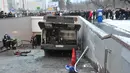 Petugas penyelamat di lokasi bus yang hilang kendali dan masuk ke dalam tangga menuju jalan bawah tanah di Moskow, Rusia, Senin (25/12). Insiden terjadi di jam sibuk pagi hari saat sedang ramai dengan pejalan kaki yang beraktivitas. (AP/Ivan Sekretarev)